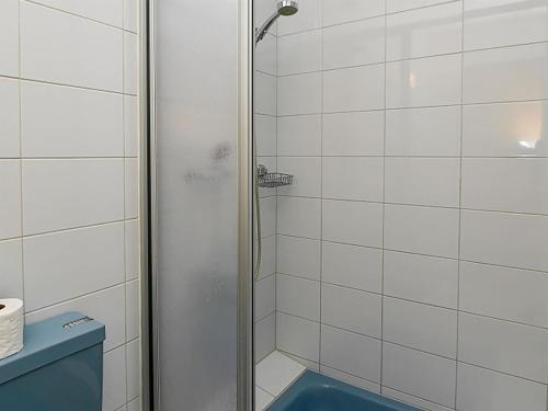 a bathroom with a shower with a blue toilet at Apartment Dorfstrasse 53c by Interhome in Engelberg