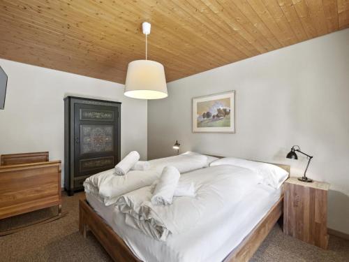 a bedroom with a large bed with white sheets at Apartment Riedblick by Interhome in Churwalden
