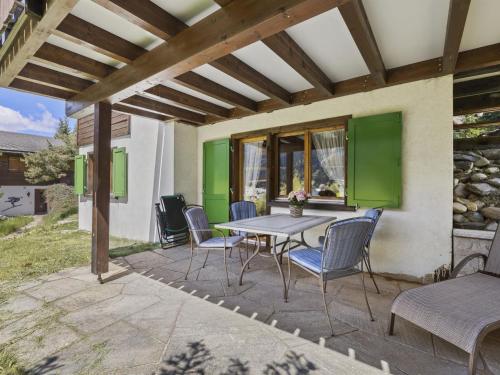 a patio with a table and chairs under a pergola at Apartment Riedblick by Interhome in Churwalden