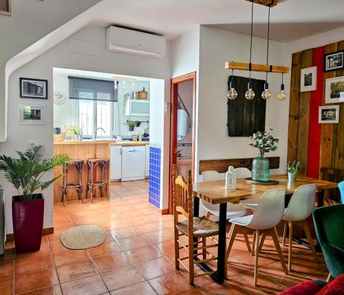 a dining room and kitchen with a table and chairs at La Casa Junto al Sendero del Río & Piscina # aire acondicionado in Los Romeros