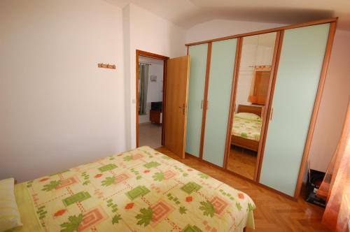 a bedroom with a bed and a mirror at Apartment Grozic in Porat
