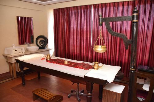 a room with a table in front of a red curtain at St Laurn The Spiritual Resort in Shirdi