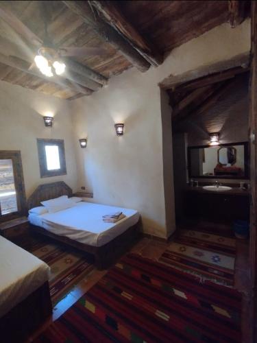 a bedroom with a bed and a tv in it at Paloma Lodge Guest House in Siwa