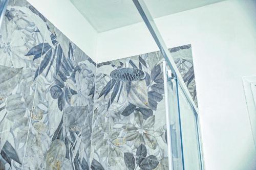 une salle de bain avec une fresque florale sur le mur dans l'établissement Casa Pepi City Center, à Sanremo