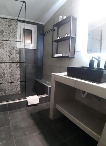 a bathroom with a sink and a shower at Boutique maison Filiatra in Filiatra