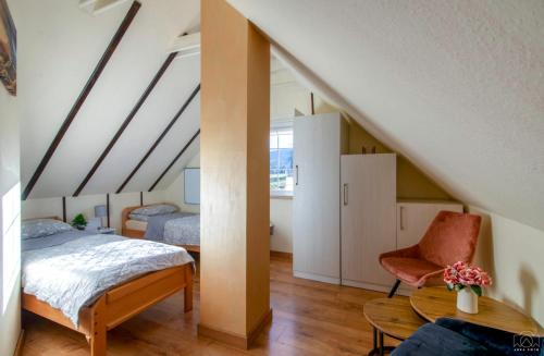 1 dormitorio en el ático con 1 cama y 1 silla en Domek u Hołąbków, en Ustrzyki Dolne