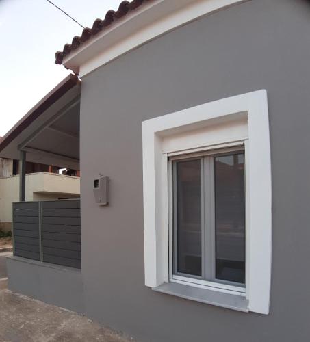 a window on the side of a white building at Boutique maison Filiatra in Filiatra