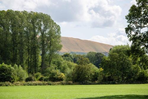 a field with trees and a hill in the background at The Caradoc in Shrewsbury