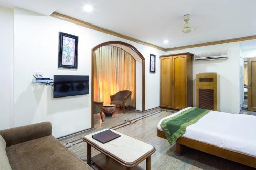 a hotel room with a bed and a couch at Garden Hotel in Mumbai