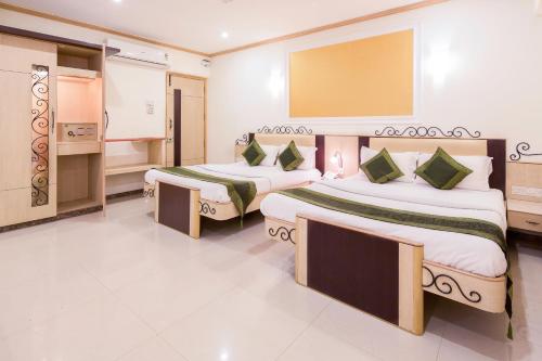 a hotel room with two beds and a bathroom at Garden Hotel in Mumbai