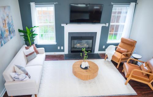 a living room with a white couch and a fireplace at Entire home in RTP near Duke with fenced backyard in Durham