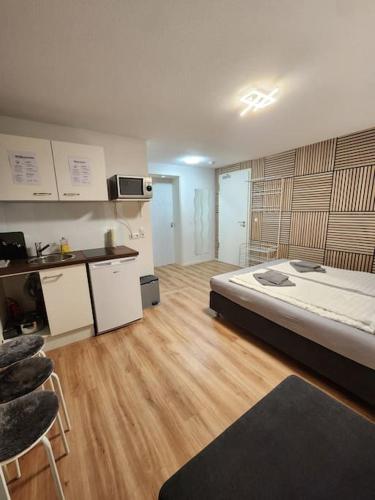 a bedroom with a large bed and a kitchen at Stuttgart City Apartment A in Stuttgart