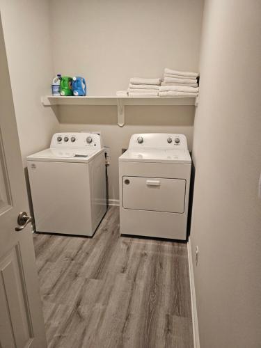 a laundry room with a washer and dryer at Spacious 4-bedroom house with WiFi, in peaceful Slidell with Lake in backyard in Slidell