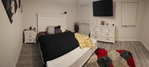 a bedroom with a bed and two dressers at Spacious 4-bedroom house with WiFi, in peaceful Slidell with Lake in backyard in Slidell