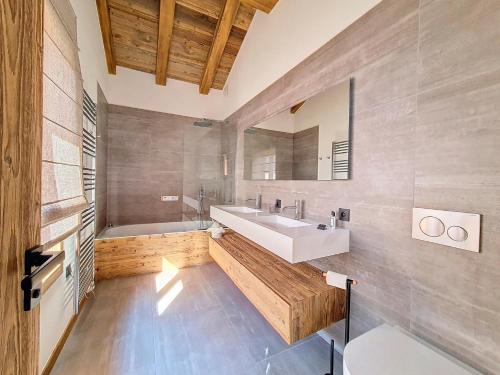 a bathroom with a sink and a tub and a mirror at Chalet La Panthère des Neiges in Saint-Martin-de-Belleville