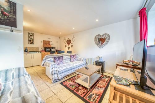 a living room with a couch and a tv at Stag Cottage New Forest Romantic Hideaway in Burley