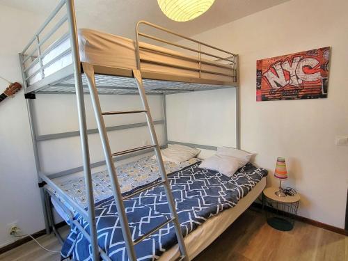 une chambre avec un lit superposé avec une échelle dans l'établissement Appartement 2 Chambres - Terrasse - Centre Station - Parking - FR-1-393-162, à Saint-Michel-de-Chaillol