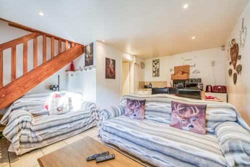 a living room with two couches and a staircase at Stag Cottage New Forest Romantic Hideaway in Burley