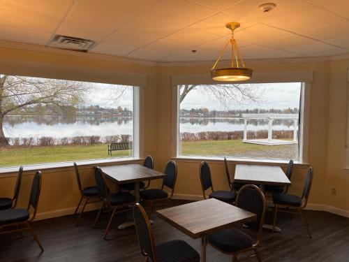 two tables and chairs in a restaurant with two windows at Lakeside Inn in Wakefield