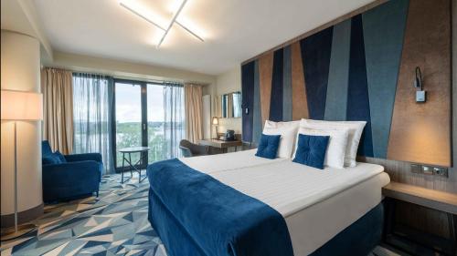 Un pat sau paturi într-o cameră la Wellton Riverside SPA Hotel