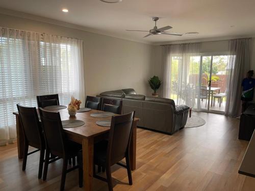 a living room with a table and a couch at Modern Four Bedroom Holiday Home Available in Deebing Heights in Loamside