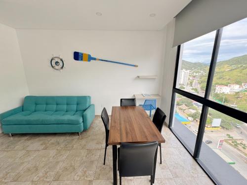 a living room with a blue couch and a table at Apartasuites VITA 945 RODADERO - By Bedviajes in Santa Marta