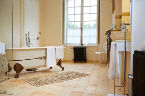 a bathroom with a bath tub and a window at Château D'arry in Arry