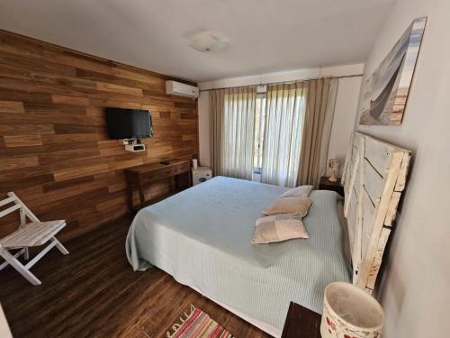 ein Schlafzimmer mit einem Bett mit einer Holzwand in der Unterkunft María Cristina Posada in Punta del Este