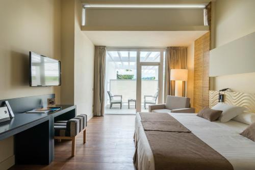 a hotel room with a bed and a desk at Hotel Alga in Calella de Palafrugell
