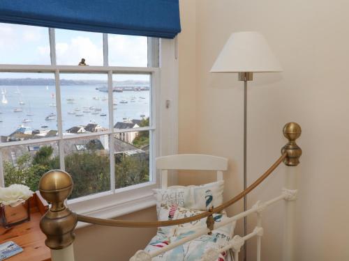 een kamer met een bed en een raam met uitzicht bij April Cottage in Falmouth