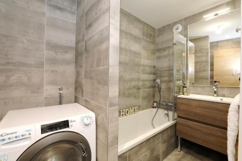 eine Waschküche mit einer Waschmaschine, einem Waschbecken und einer Waschmaschine in der Unterkunft Discover this new apartment with your family in Saint-Bon-Tarentaise