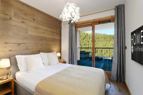 ein Schlafzimmer mit einem Bett und einem großen Fenster in der Unterkunft Discover this new apartment with your family in Saint-Bon-Tarentaise