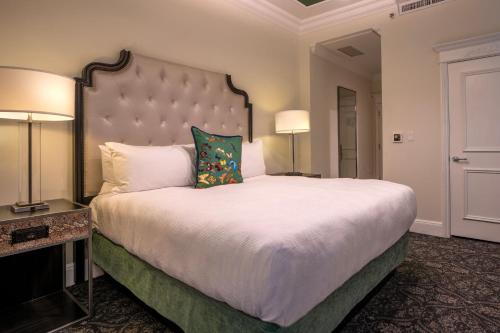 a large bed in a hotel room with two lamps at Le Pavillon, New Orleans, a Tribute Portfolio Hotel in New Orleans