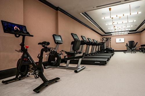 a gym with a row of treadmills and exercise bikes at Le Pavillon, New Orleans, a Tribute Portfolio Hotel in New Orleans