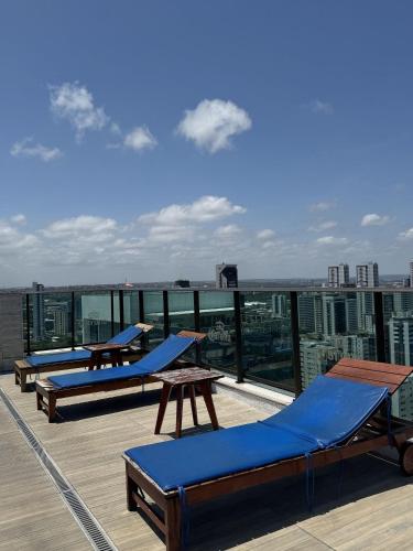 a row of lounge chairs and tables on a roof at Pontes Home Stay - Flats em Boa Viagem por Yolo in Recife