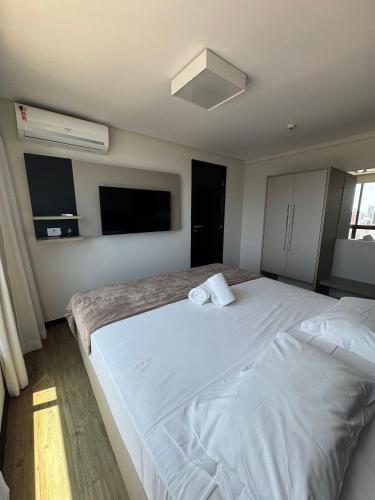 a bedroom with two beds and a flat screen tv at Pontes Home Stay - Flats em Boa Viagem por Yolo in Recife