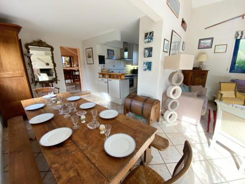 - une table à manger avec des assiettes et des verres à vin dans l'établissement KERBELEM - Jardin, Terrasse, Plages 3km - C29, à Carnac