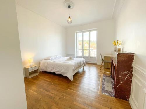 une chambre blanche avec un lit et un bureau dans l'établissement Le Saint'élégant Wifi Calme Rénové, à Saint-Étienne