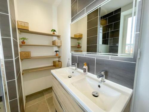 une salle de bain avec un lavabo et un miroir dans l'établissement Le Saint'élégant Wifi Calme Rénové, à Saint-Étienne