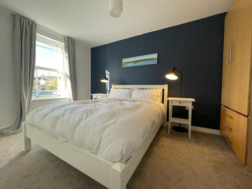 a bedroom with a large bed with a blue wall at Light-filled Eco-home with Patio in Bristol