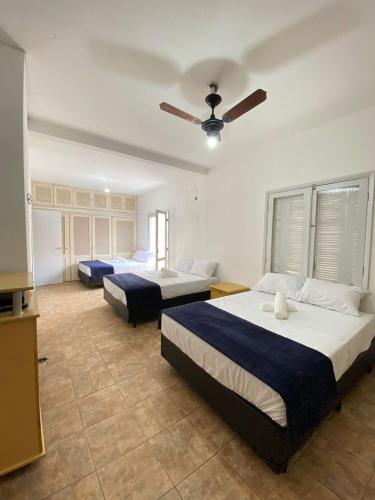 a bedroom with two beds and a flat screen tv at Santorini House in Guarujá