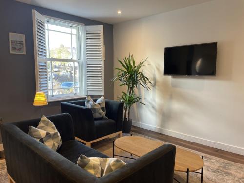 a living room with two couches and a tv at Light-filled Eco-home with Patio in Bristol