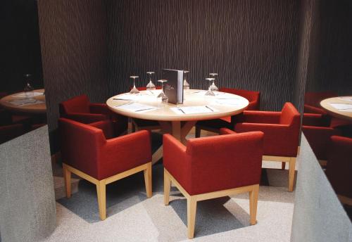 a table and red chairs in a room with a table and chairsktop at Met Hotel in Izmir