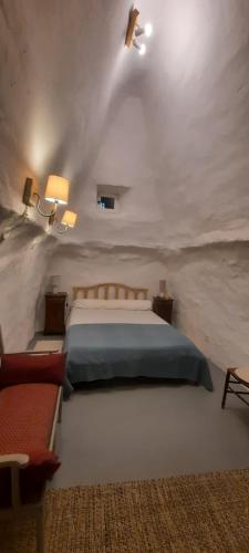 une chambre avec un grand lit dans une pièce blanche dans l'établissement Ancien relais de chasse, isolé en pleine nature provençale 11 couchages, modulable 7, à Saumane-de-Vaucluse