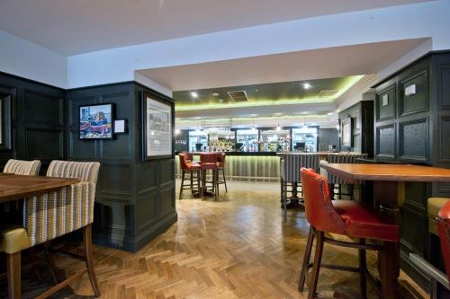 a restaurant with green walls and wooden tables and chairs at The Saltoun Inn in Fraserburgh
