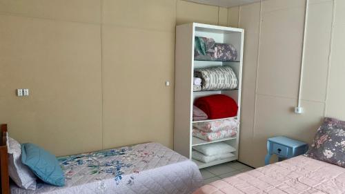 a bedroom with a bed and a closet at Cantinho da Tia Dori in Rio Forcação