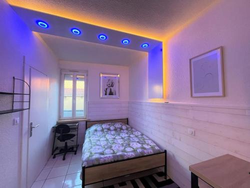 a bedroom with a bed in a room with purple lights at Lion d'or 27 Chambre meublée et équipée centre-ville in Montluçon