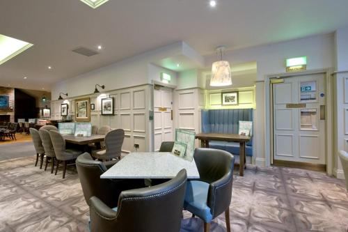 a waiting room with tables and chairs in a building at The Saltoun Inn in Fraserburgh