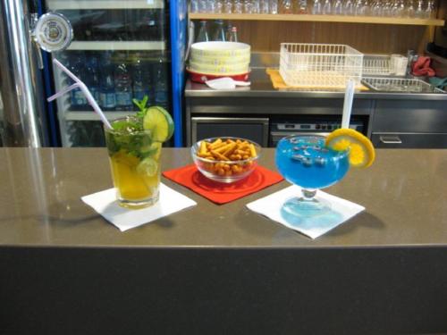 a counter with two drinks and a bowl of fruit at Albergo Gusmeroli in Tirano