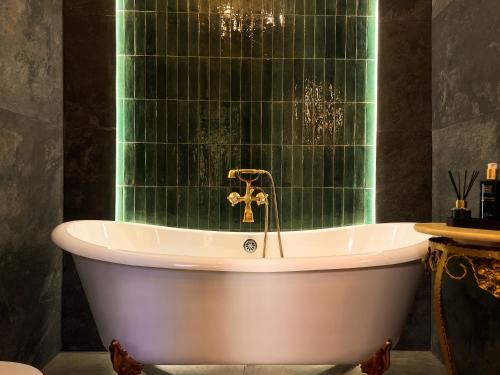 a bath tub in a bathroom with a green wall at La Mia Amore in Kotor